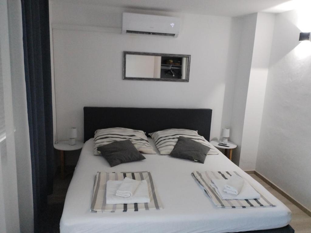 een slaapkamer met een bed met twee borden erop bij Apartment Happy 2 in Pakoštane
