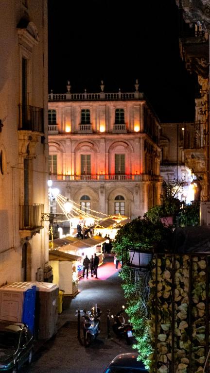a building at night with people walking in front of it at Notti d'Autore Suites in Catania