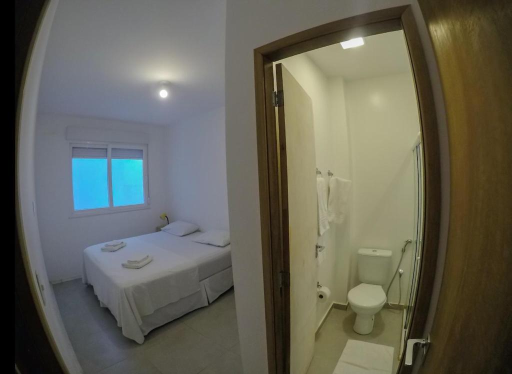um quarto com uma cama, um WC e um espelho em Fullano B&B no Rio de Janeiro