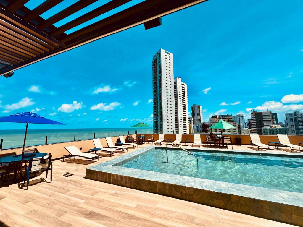 a swimming pool with a view of the beach and buildings at Park Hotel in Recife