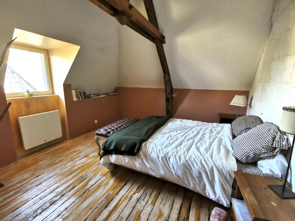 Schlafzimmer mit einem Bett und Holzboden in der Unterkunft Chambre d'hôtes EPI in Ingrandes