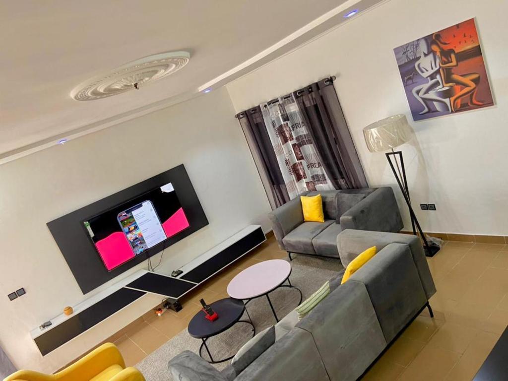 uma sala de estar com um sofá e uma televisão de ecrã plano em Luxe minontin em Cotonou