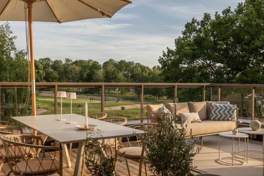 a patio with a couch and tables and chairs at The Oak - Ekerum Öland in Borgholm