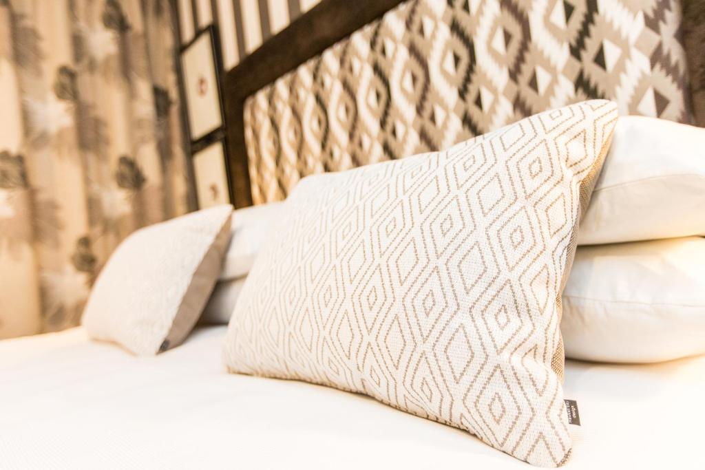a bed with white pillows on it at ASURE Destiny on Fitzherbert Motel in Palmerston North