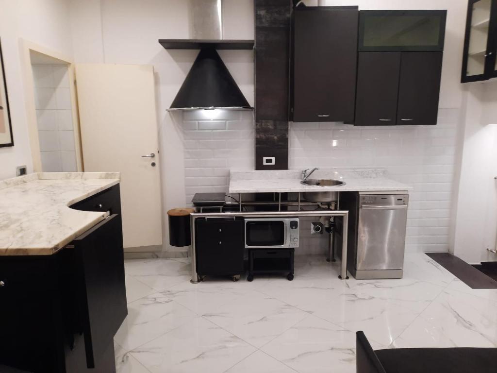 a kitchen with stainless steel appliances and black cabinets at Studio Apartment Santa Caterina in Bologna