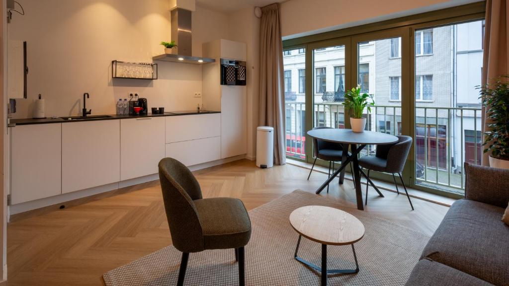 una cucina e un soggiorno con tavolo e sedie di Pacific Residences - Studio ad Anversa