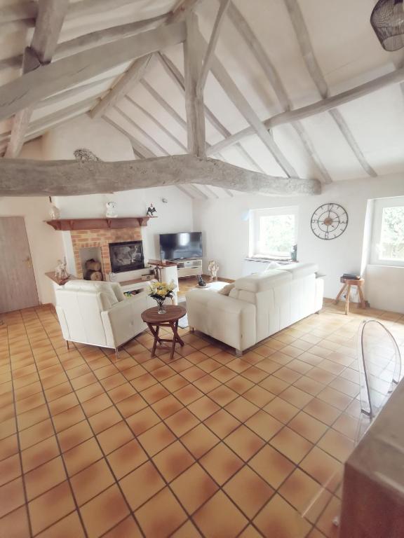 - un salon avec deux canapés blancs et une télévision dans l'établissement Le Petit Rosnel, à Saint-Jean-de-Monts