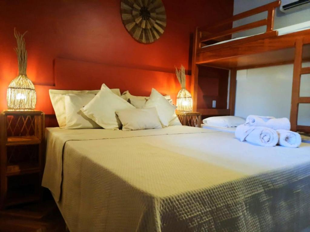 a bedroom with a large bed with towels on it at Ayo Bistrô Pousada in Marau