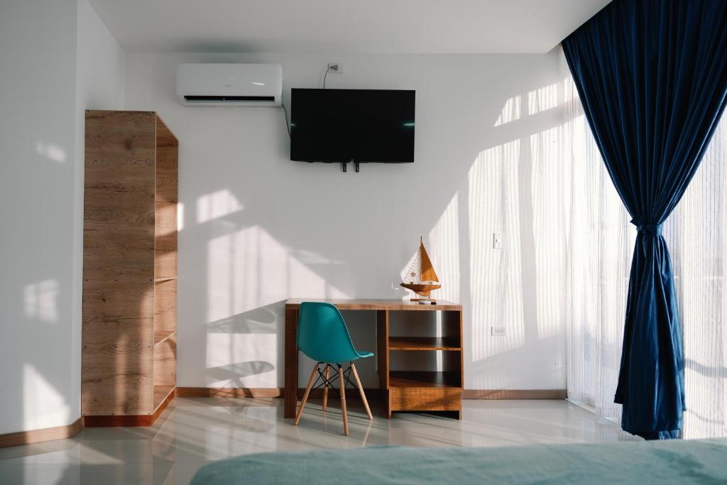 a bedroom with a desk and a green chair at Modernas Habitaciones in Puerto Ayora