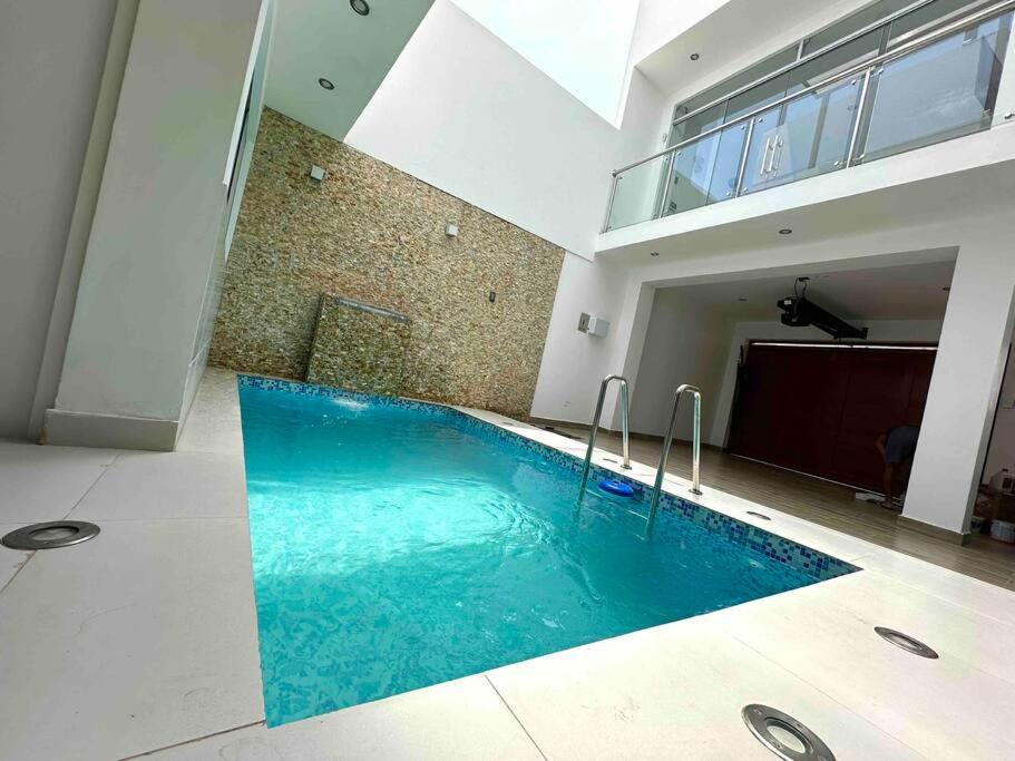 a swimming pool in the middle of a building at Aura Chincha® Casa con Piscina, Karaoke y más! in Chumbiaula