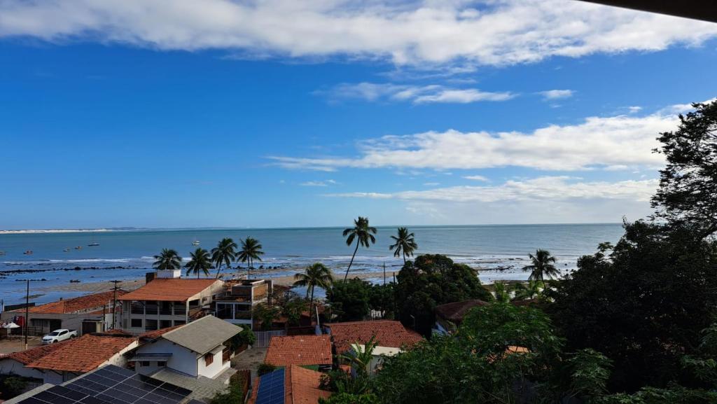 Blick auf einen Strand mit Palmen und das Meer in der Unterkunft Casa do Sol in Pipa