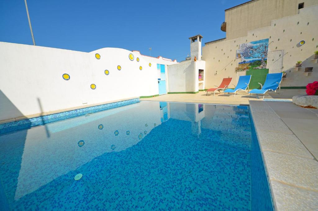 een zwembad met blauwe stoelen in een gebouw bij CASA MONDRIAN in Tiggiano