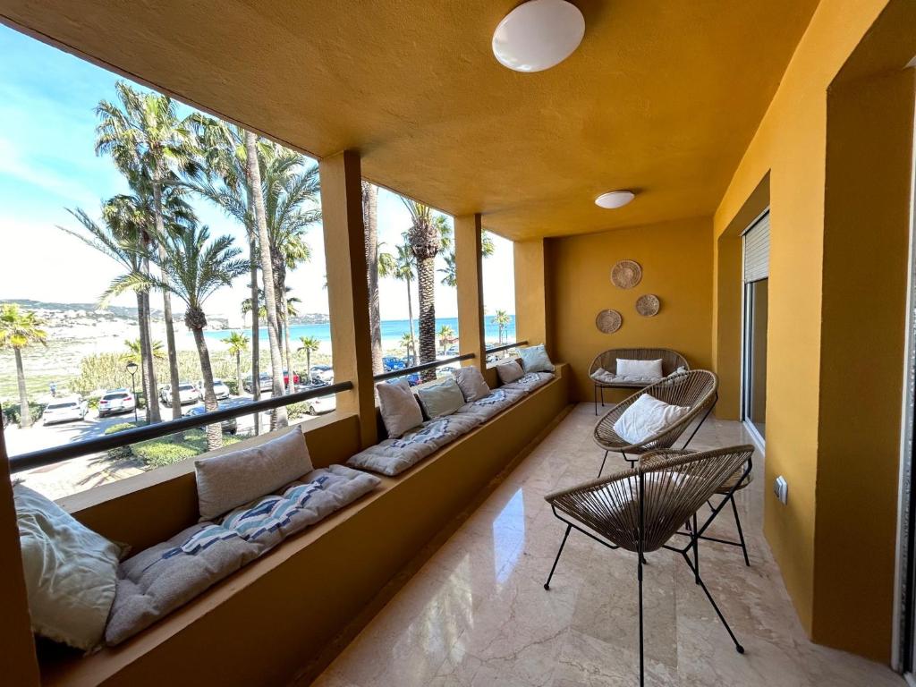 a living room with a long couch and a large window at Puerto Sotogrande con vistas al mar in Sotogrande