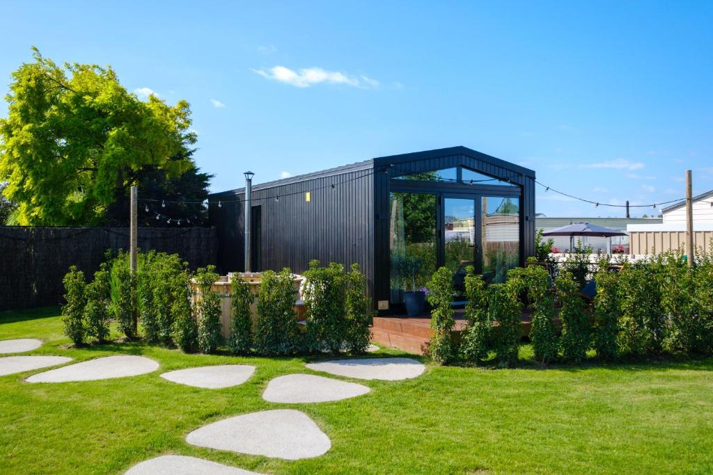 a garden with a black building in the background at B-LESS in Blankenberge