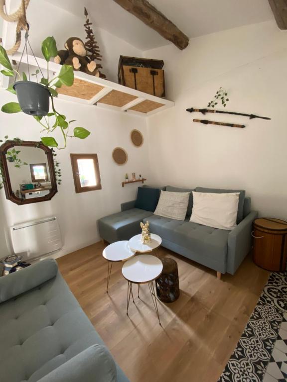 un soggiorno con divano e tavolo di Logement atypique avec jacuzzi inclus a Mallemort