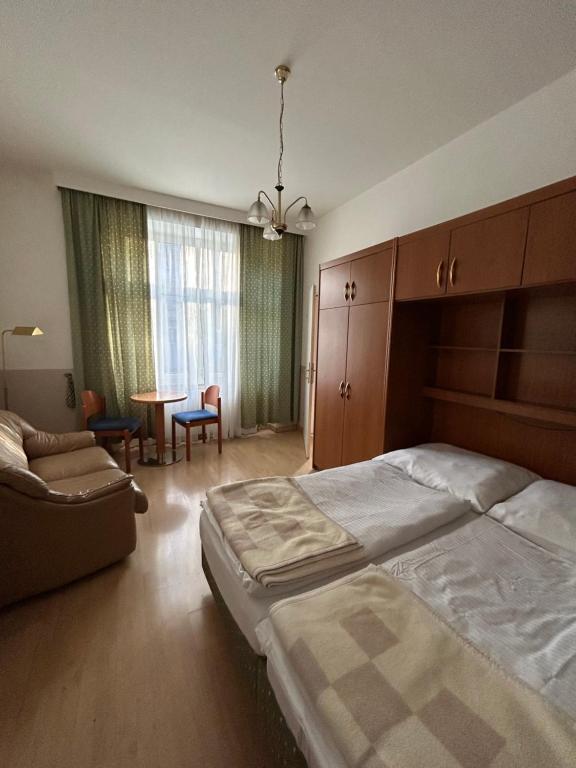 sypialnia z łóżkiem, krzesłem i stołem w obiekcie Reiner Apartment w Wiedniu