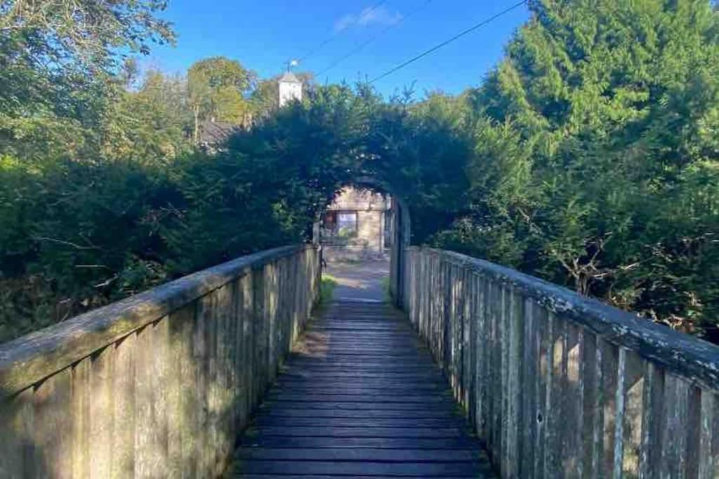 a wooden bridge with an arch over a road at Town Centre Apartment in Mold