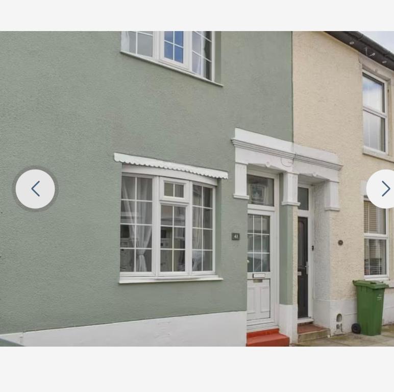 een groen huis met een raam en een deur bij Southsea Home Stay : 2 Bedroom House with Garden and Hot Tub in Portsmouth