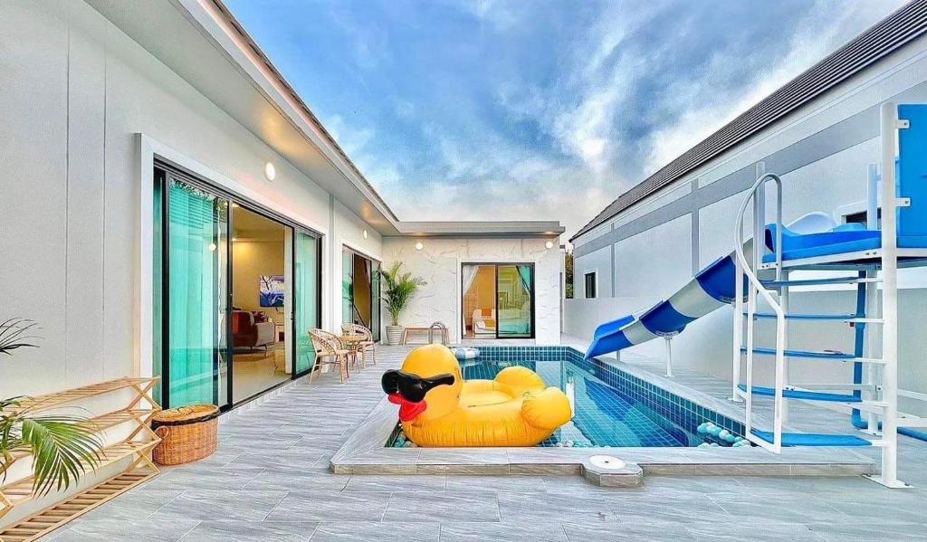 a house with a pool with a large inflatable pool slide at GK Pool Villa in Ban Thap Tai (1)