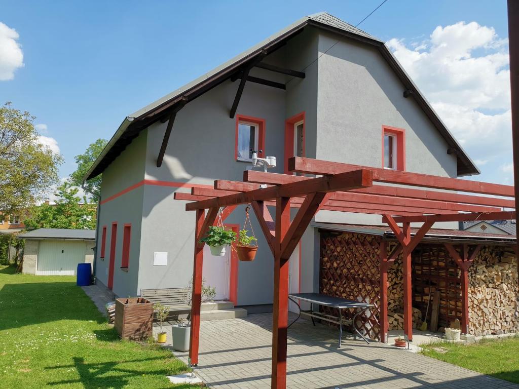 een huis met een houten pergola ervoor bij Apartmán u Šálku in Varnsdorf