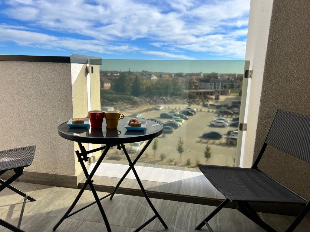 a table on a balcony with a view of a parking lot at Bonvenon in Szombathely