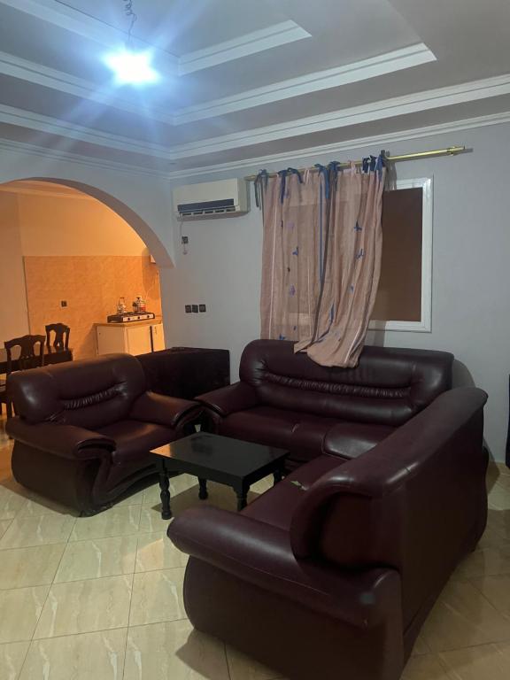uma sala de estar com dois sofás de couro e uma mesa em Appartement 5 en 2eme étage em Oujda