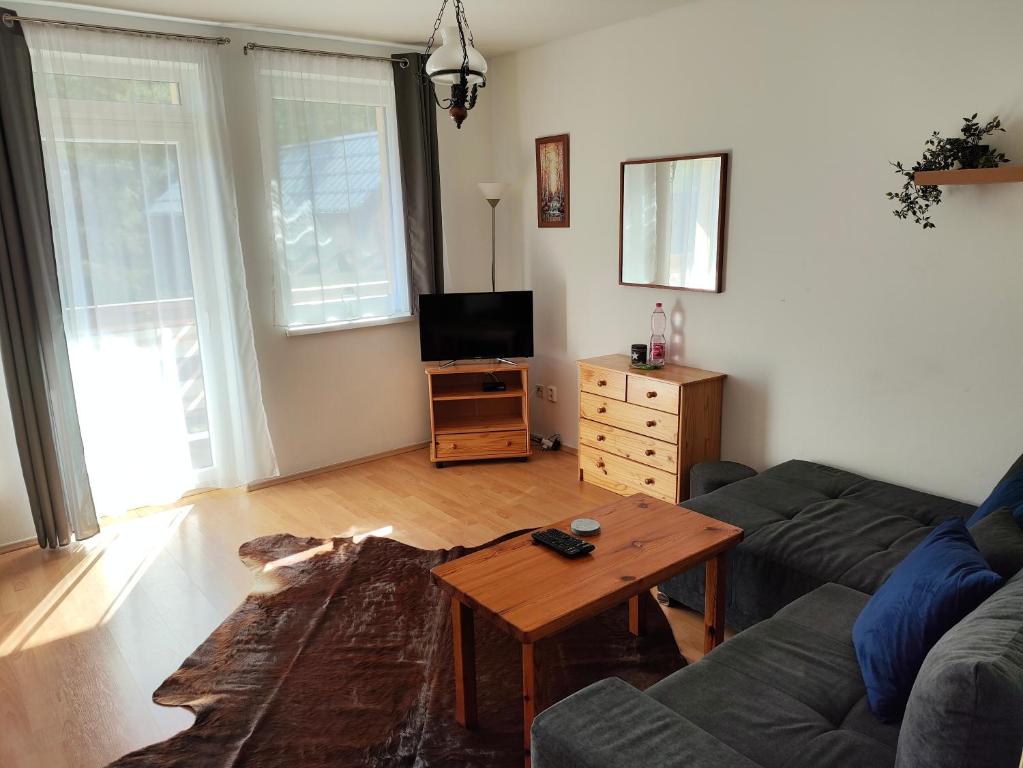 uma sala de estar com um sofá e uma mesa em Apartmán LUCKA em Donovaly
