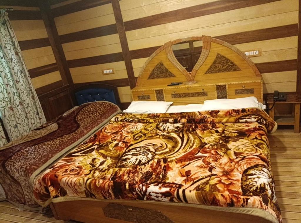een bed met een houten hoofdeinde in een kamer bij Royal stay in Srinagar
