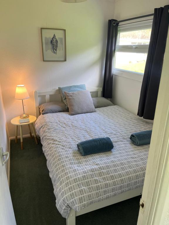 a bedroom with a bed with two pillows on it at Chalet 77, Kings Chalet park,Cromer,North Norfolk. in Cromer
