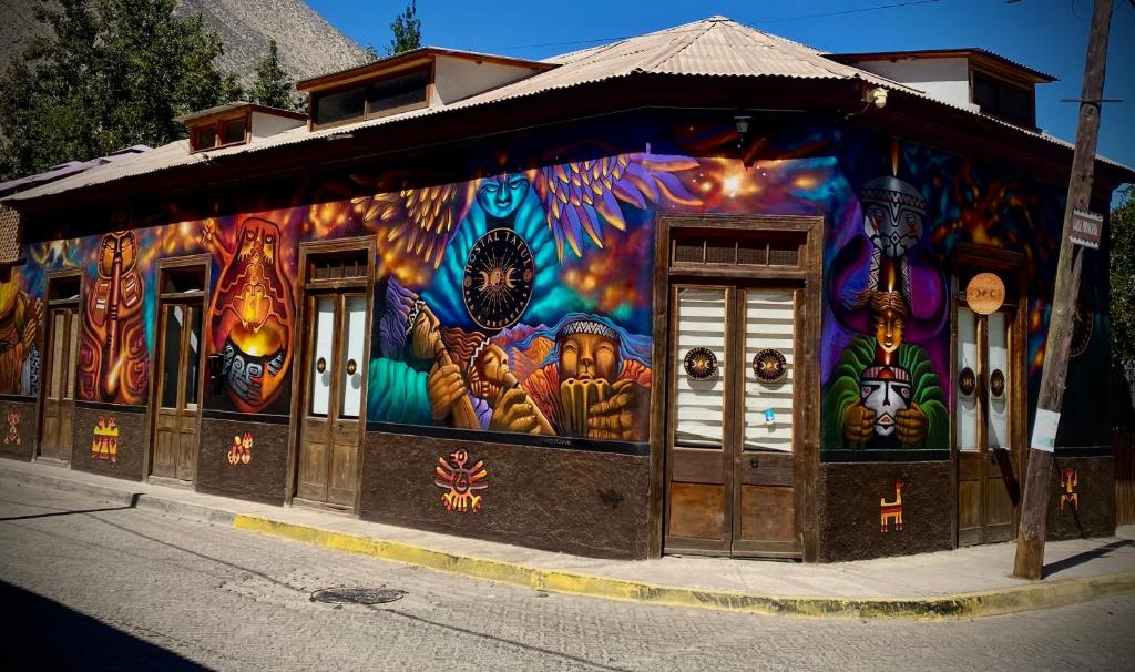 un edificio con un mural colorido en su lado en Hostal Tatul en Diaguita