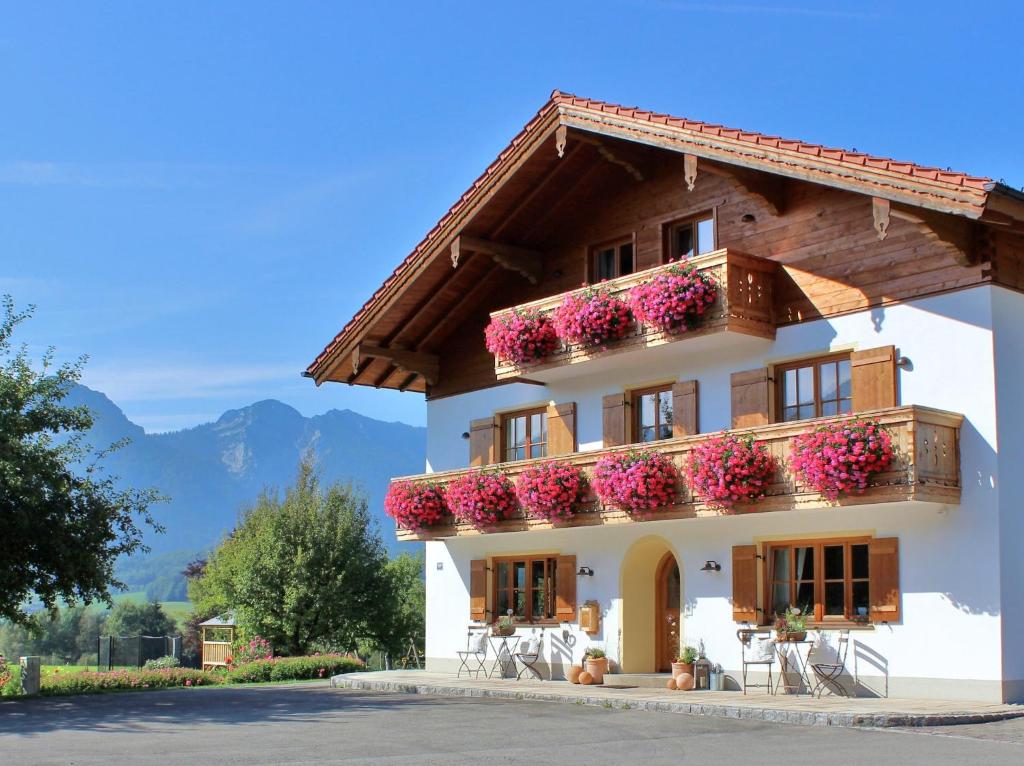 ein weißes Haus mit Blumen auf dem Balkon in der Unterkunft Sotterhof - Chiemgau Karte in Inzell