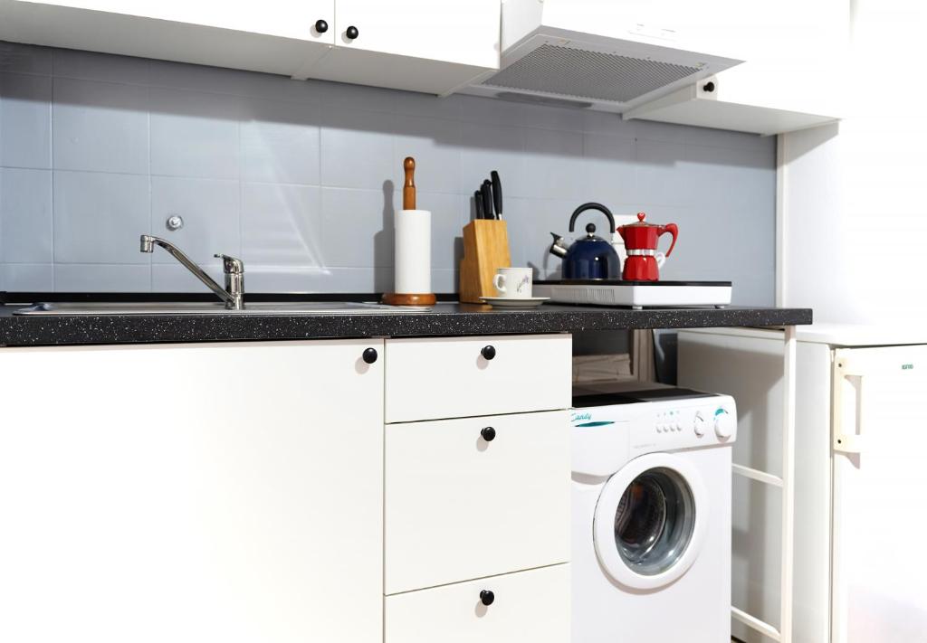 una cucina bianca con lavatrice e asciugatrice di Lago Iseo View a Zone