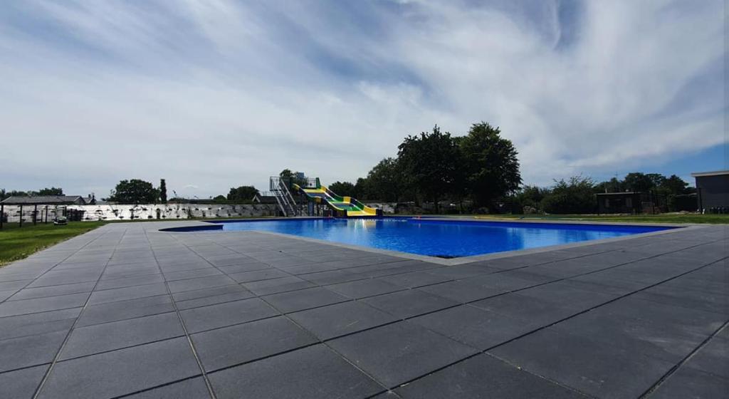 a swimming pool with a slide in the background at Perenhof 6 in Oostvoorne