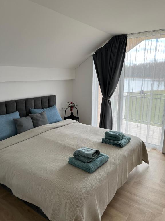 a bedroom with a large bed with two towels on it at Panacea in Lazdijai