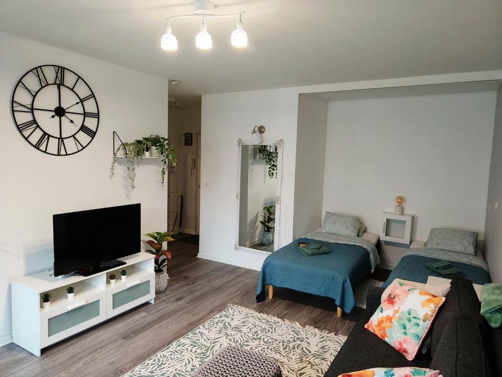 City Apartment في تامبير: غرفة معيشة بها أريكة وتلفزيون وساعة