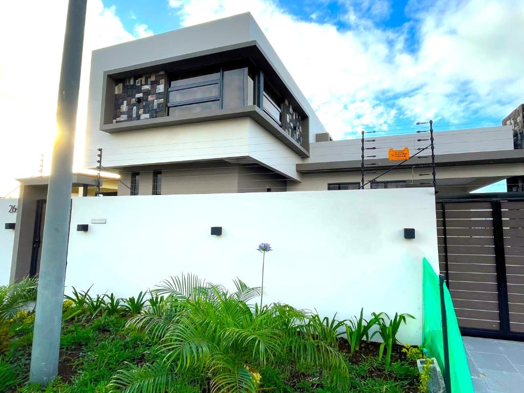 a large white building with a balcony on top of it at Palms Haven - Mauritius - Modern and luxury vacation home in Phoenix
