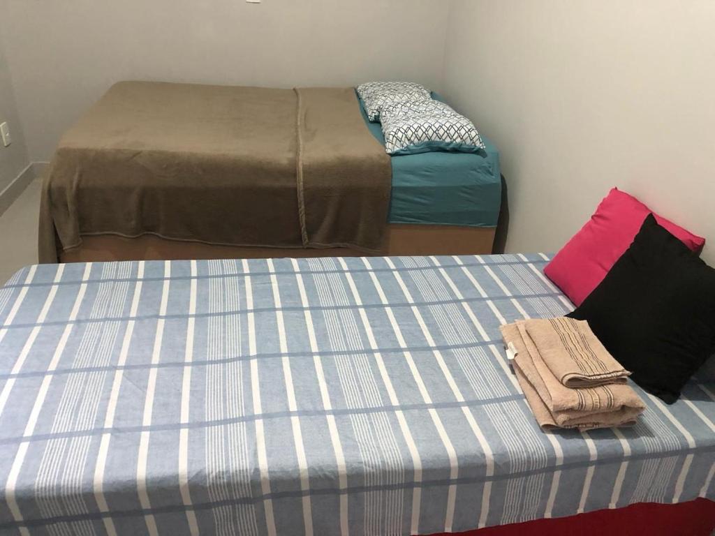 dos camas sentadas una al lado de la otra en una habitación en Residencial Jasmim en Palmas