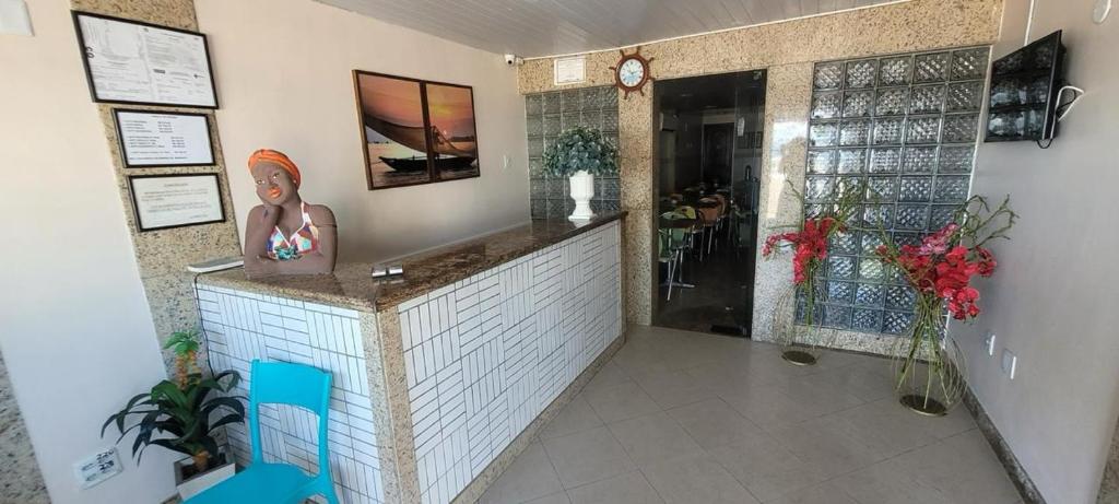 a restaurant with a statue of a woman on a counter at Hotel Porto Da Barra in Salvador