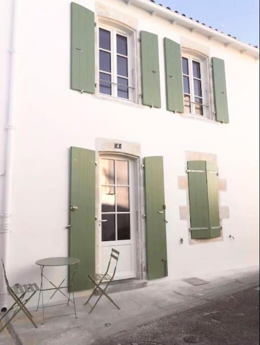 2 chaises et une table à l'extérieur d'un bâtiment dans l'établissement Les 4 Belles maison Ile de Ré, à Sainte-Marie de Ré