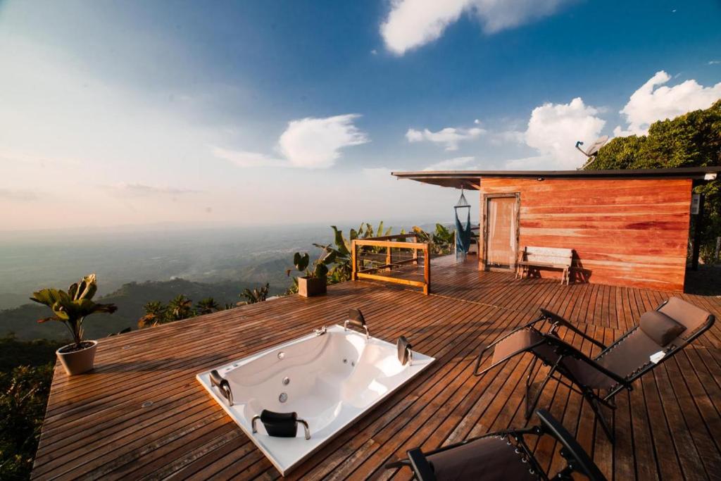 a bath tub on a wooden deck with chairs at El Refugio in Quindío