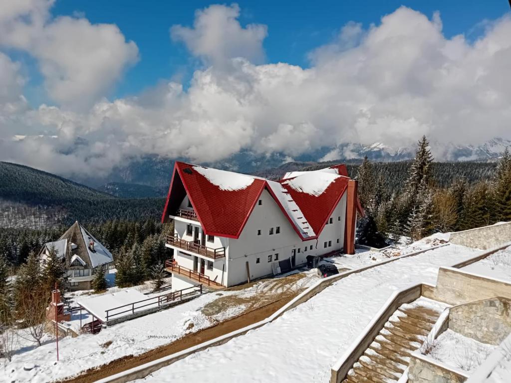 uma casa com um telhado vermelho na neve em Rusticanna em Ranca