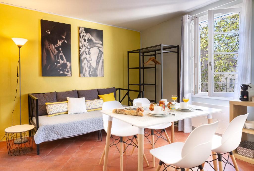 un salon avec un canapé, une table et des chaises dans l'établissement Centre Palais des Papes B3 Clim - 123avignon, à Avignon
