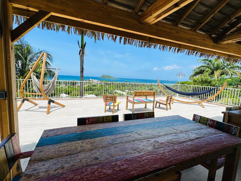 a patio with a hammock and a view of the ocean at Résidence Vue Mer in Deshaies