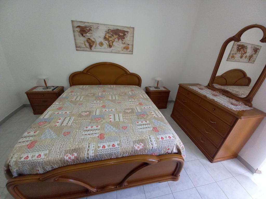 ein Schlafzimmer mit einem Bett und einer Kommode darin in der Unterkunft La Dimora di Ketty in Scicli