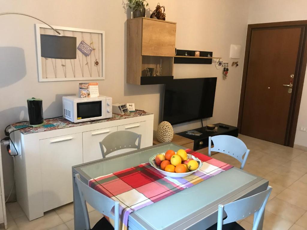 una cocina con una mesa con un bol de fruta. en Casa Vacanze La Carezza en Montesilvano