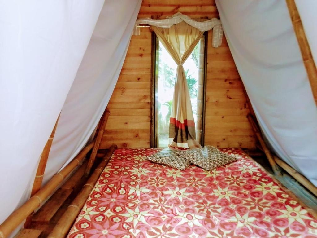 Hostal Colina de San Antonio في Jamundí: غرفة نوم بسرير في خيمة مع نافذة