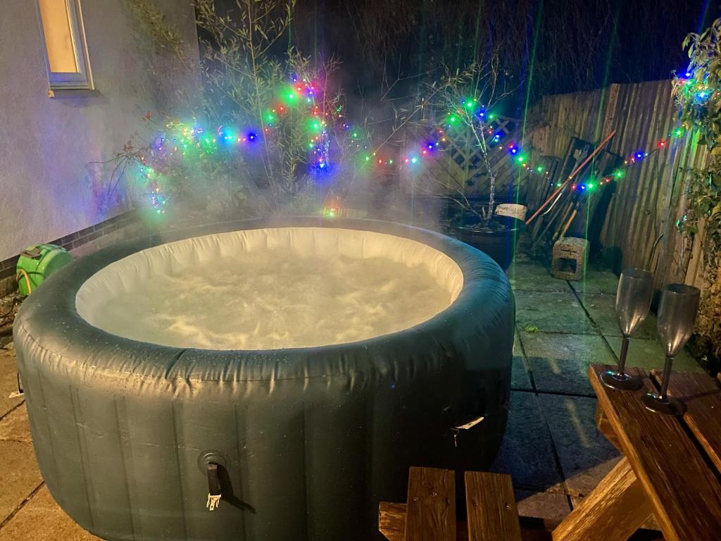a large tub with christmas lights in a yard at Large New Studio Apartment and Hot Tub - Private Hideaway in the Brecon Beacons in Bwlch
