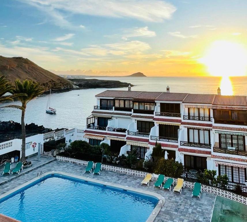 a hotel with a swimming pool in front of the ocean at Apartment with beautiful ocean view in Costa Del Silencio