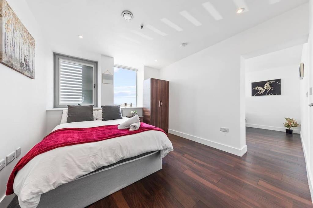 ein Schlafzimmer mit einem großen Bett mit einer roten Decke in der Unterkunft New Apartment 20 mins from London Waterloo BP65 in London
