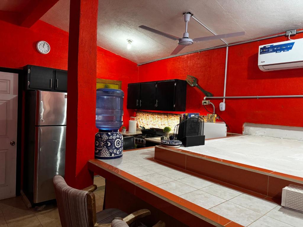 a kitchen with red walls and a counter with a blender at Departamento Kassandra in Puerto Peñasco